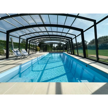 Lång rektangulär inomhuspool med klar blåvatten och svartramat glastak för Bahama trädgårdspool med transparent pooltak