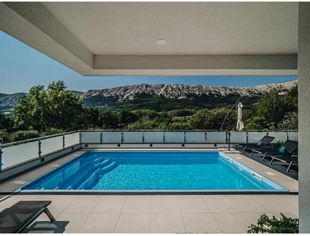 Blå rektangulär glasfiberpool Aruba med kaklad omgivning