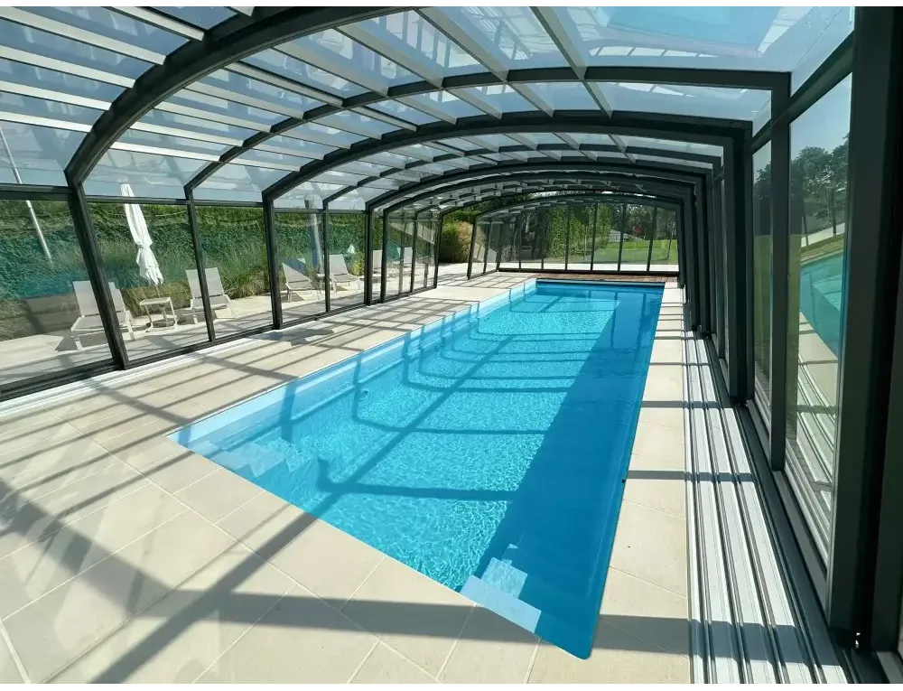 Lång rektangulär inomhuspool med Bahama trädgårdspool och transparent pooltak