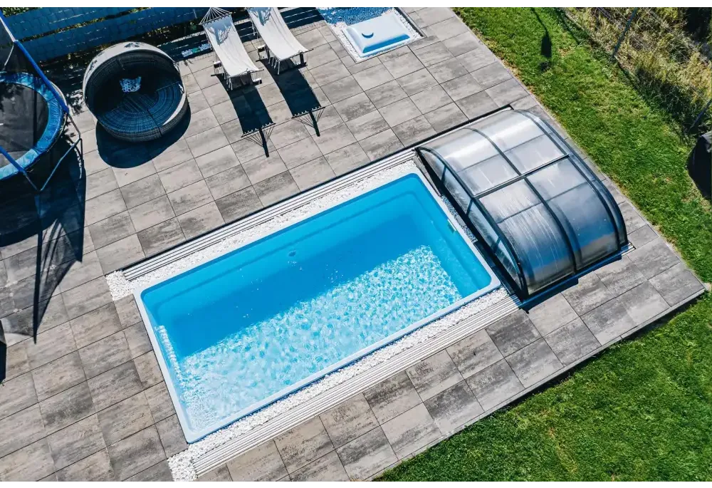 Glasfiberpool Papeete med elegant pooltak och klarblått vatten