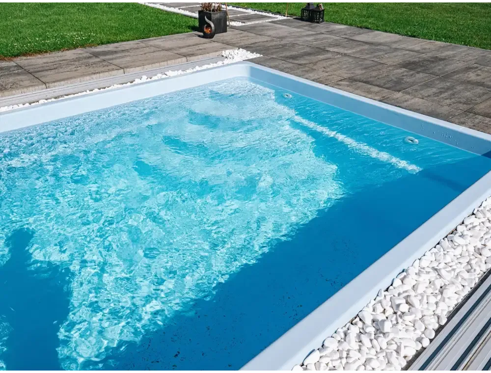 Modern glasfiberpool Papeete med pooltak, rektangulär med klart blått vatten och vita stenar