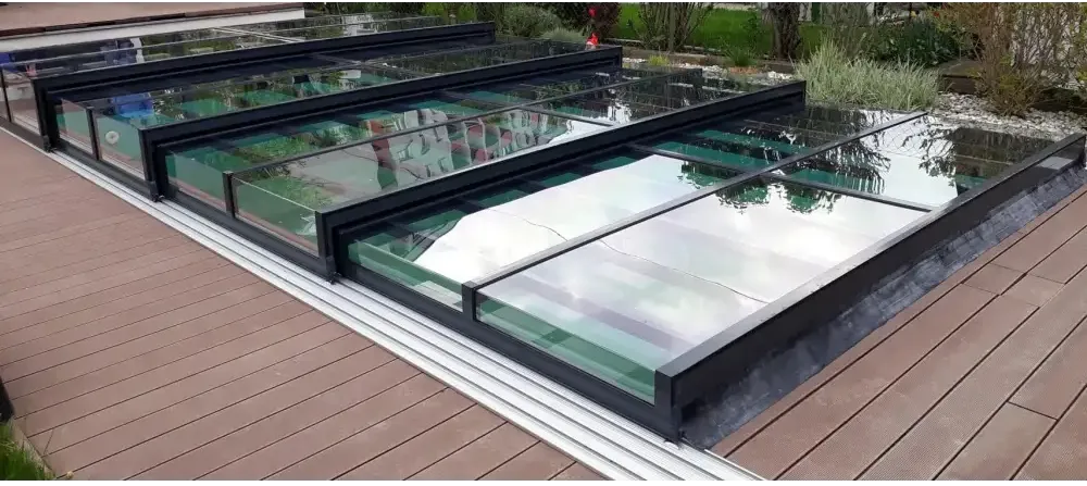 Moderna svarta ramade glasplattor på trädeck med Pooltak Icon i klarplast antracit