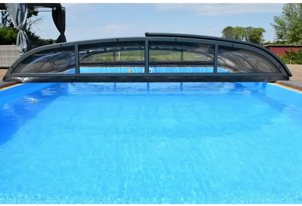 Svart valvformat pooltak Nivo Kit 650B med transparenta paneler över blå pool