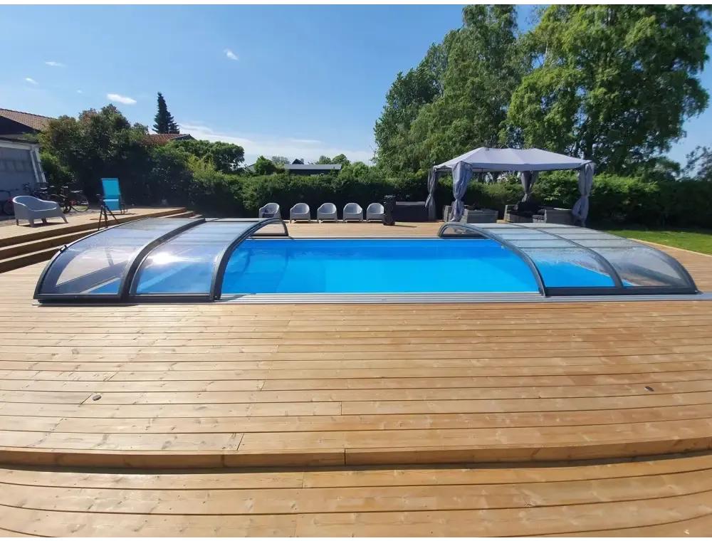 Blå pool med transparent bågad pooltak Nivo Kit 750B på trädeck