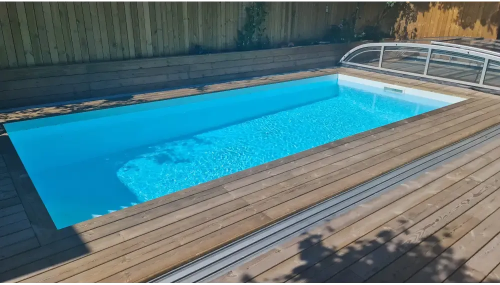 Rektangulärt pooltak Nivo Kit 860B med klart blått vatten, trädeck och glasruta