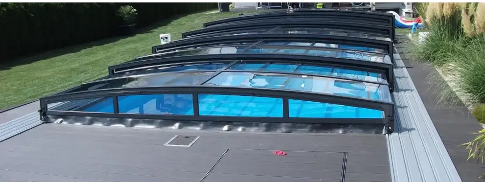 Pooltak special med böjd glasdesign och svart ram över blå pool