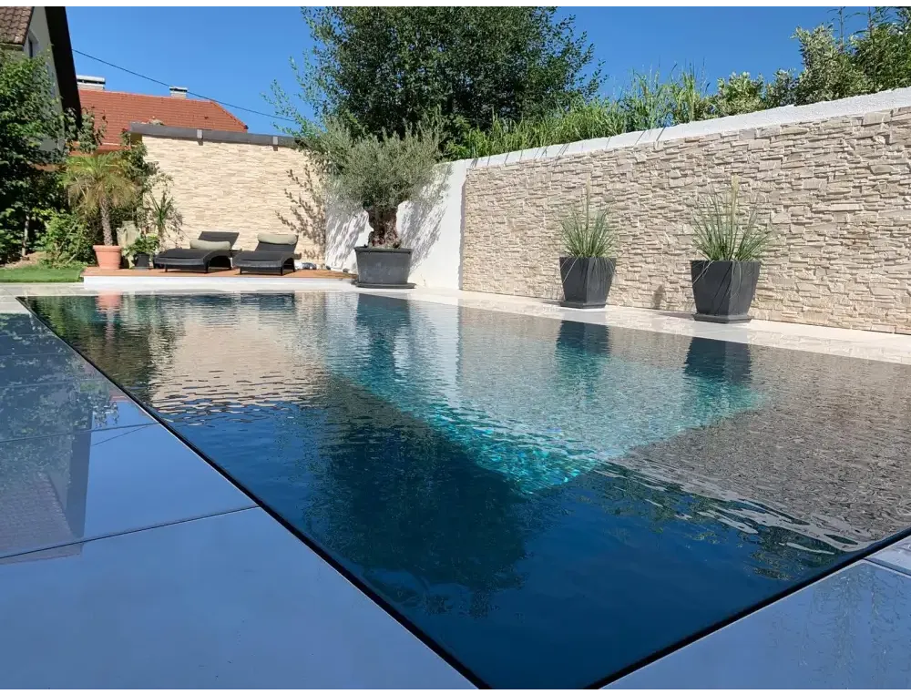 Exklusiv overflow pp pool med rektangulär form, klar blå vatten och ljusgrå kakelkant