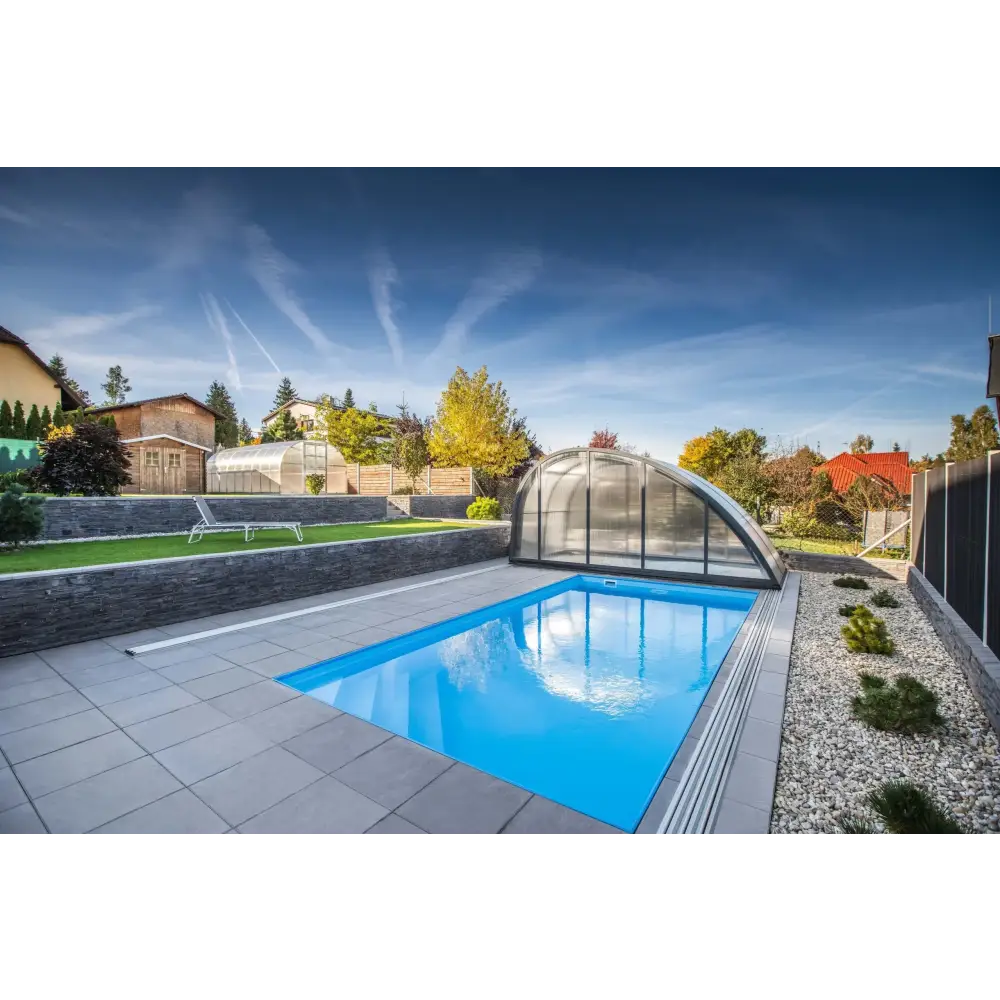 Blå rektangulär pool med transparent valv och grå stenplattor i Thermopp Poolpaket Qbig